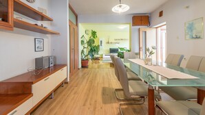 A modern kitchen with wooden cabinets, a built-in oven, and a large window. - Apartment Villa Odesa - Two Bedroom Apartment with Balcony, shared Swimming Pool (Zadar)