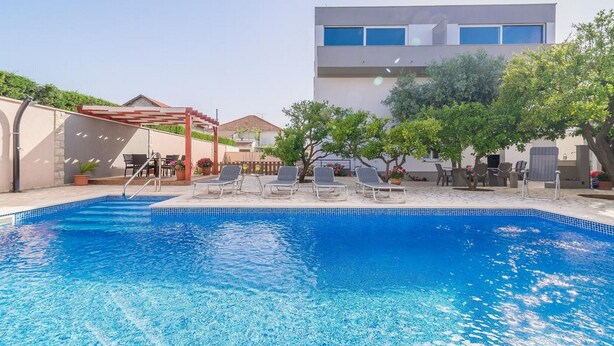 A swimming pool with lounge chairs and a pergola. - Apartment Villa Odesa - Two Bedroom Apartment with Balcony, shared Swimming Pool (Zadar)