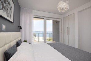 A bedroom with a bed, a large window, a balcony, and a view of the sea. - Apartments Lueva - Duplex Three Bedroom Apartment with Balcony and Sea View (A3) (Privlaka)