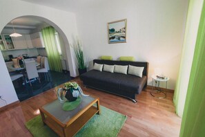 A living room with a sofa, a coffee table, and a painting on the wall.