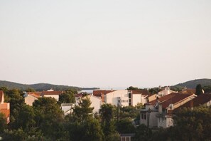 Ein Küstenwohngebiet mit Häusern, Bäumen und Hügeln im Hintergrund.