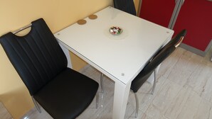 Un área de comedor con una mesa blanca, sillas negras y un pequeño cuenco decorativo sobre la mesa.
