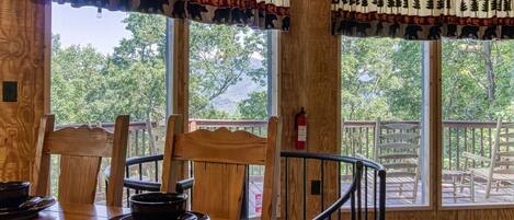 Un interno in legno con ampie finestre che si affacciano su una terrazza e alberi.