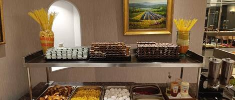Una barra de buffet con diversos alimentos y acompañamientos.