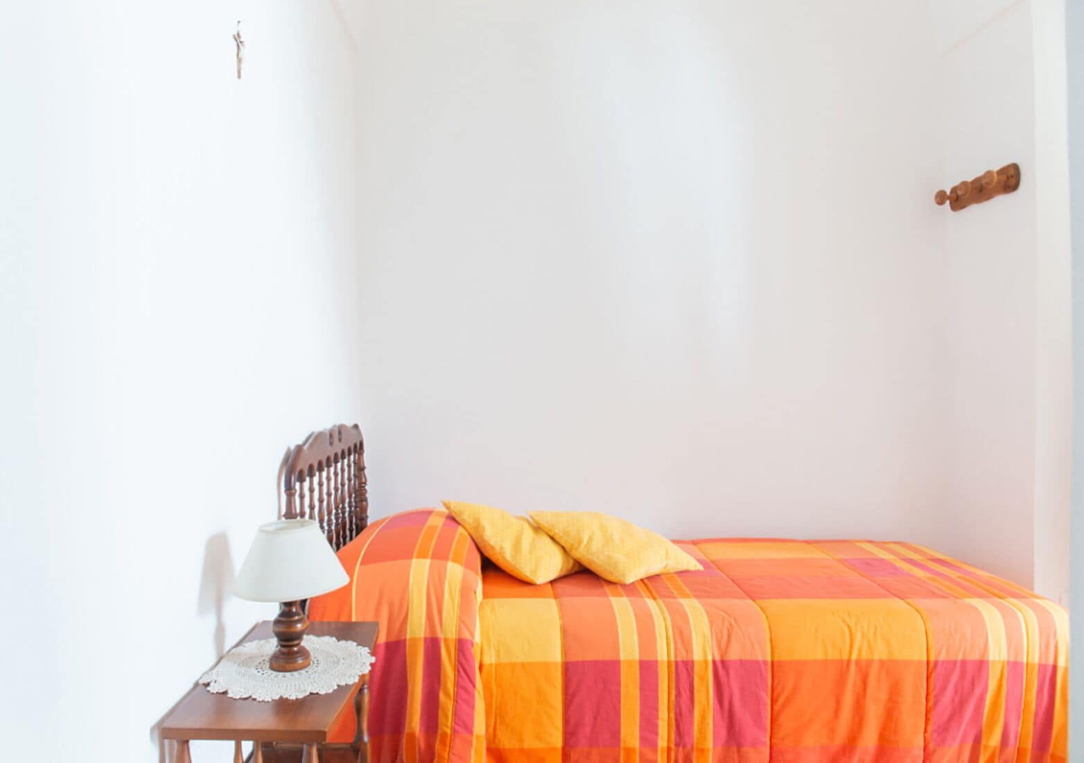 Ein Schlafzimmer mit Bett, Nachttisch, Lampe und Heizkörper.