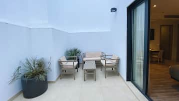 A small patio area with a sofa set and a potted plant.