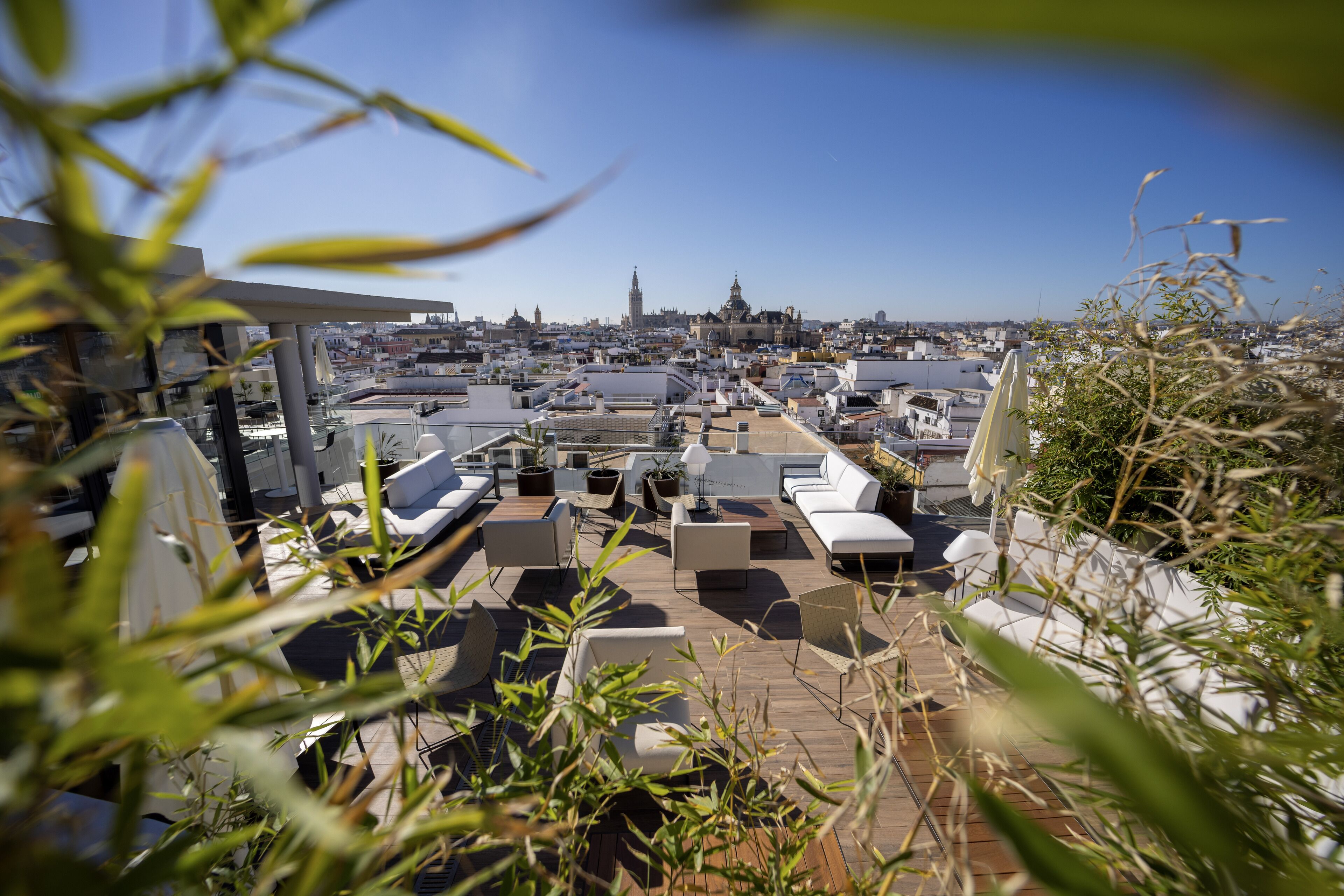 A rooftop terrace with multiple seating areas and a view of the cityscape.
