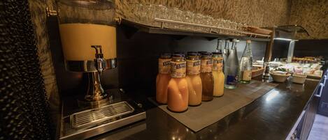 A beverage station with a coffee machine, a milk dispenser, and several bottles of milk and other beverages.