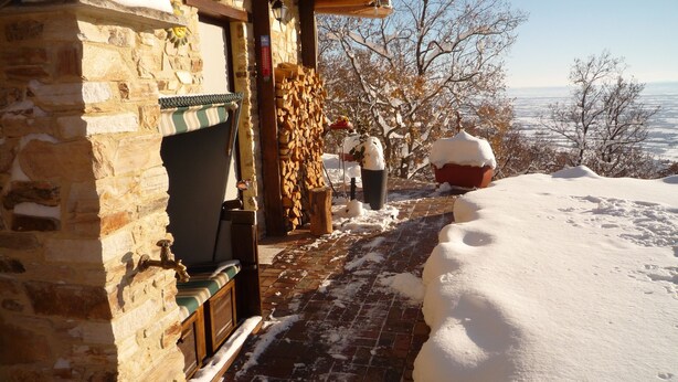 Un edificio de piedra con un banco de madera y una chimenea.