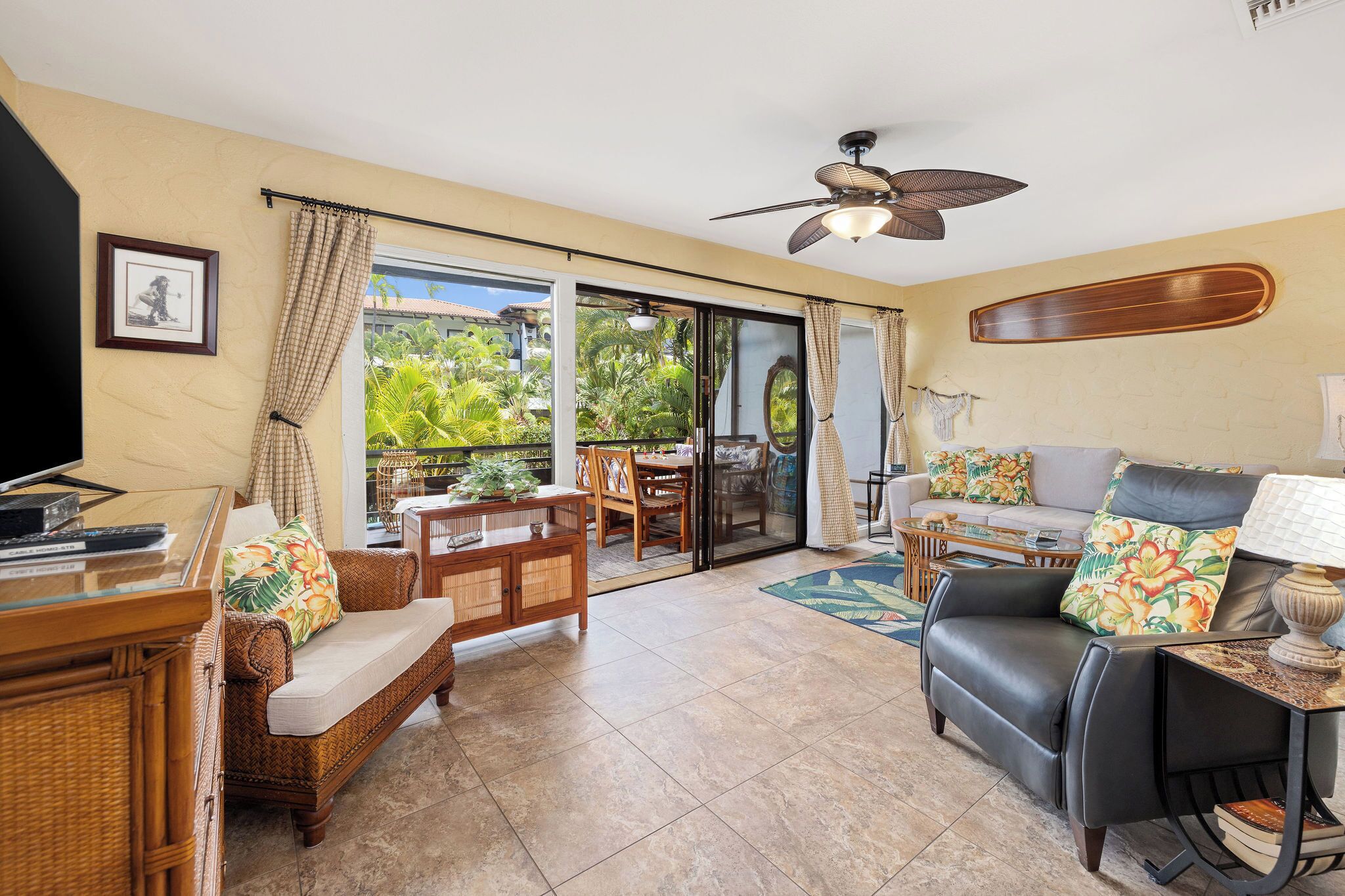 A spacious living area with a sofa, armchair, and a dining table.