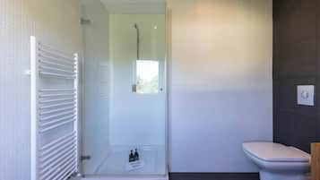 A modern bathroom with a glass-enclosed shower, a white toilet, and a towel rack.