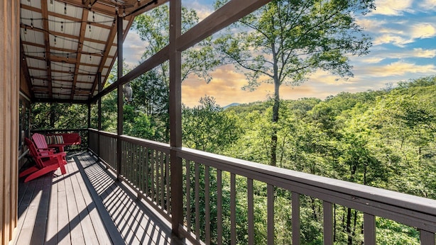 Terraza de madera con vista a un paisaje boscoso.
