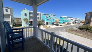 A porch with a view of a residential street. - Custom 3BR 3BA with Private Pool & Elevator - new in 2022 (Sunset Beach)