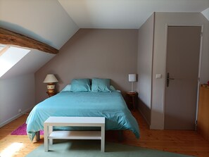 A bedroom with a bed, two bedside tables, a bench, a door, and a skylight. - Cottage 2 to 9 people La Chaumière de Mauvrain, out of time, forest 100m (La Celle sur Nièvre)