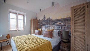 A bedroom with a bed, a chair, a window with blinds, a wardrobe, and a mural of a bridge. - Comte de Clare, 4 stars, Cosy apartment close to the Champs-Elysées (París)