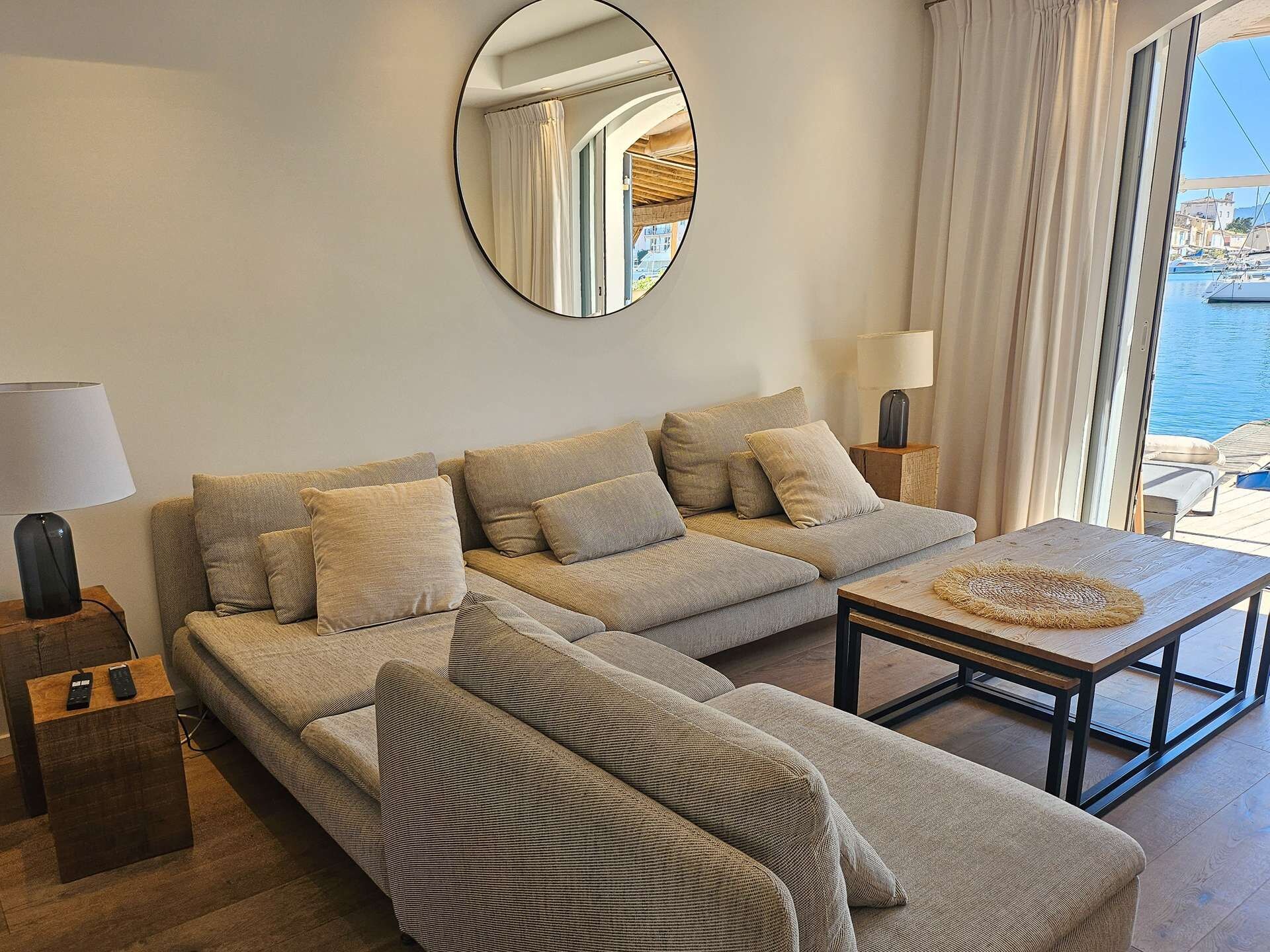 Una sala de estar moderna con un sofá, una mesa de centro y un espejo grande en la pared.