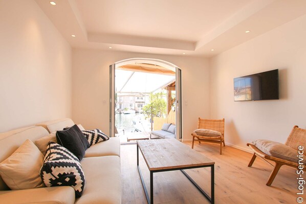 A modern living room with a sofa, a coffee table, and two wicker chairs.