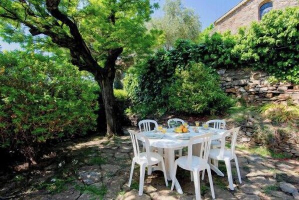 Enjoy al fresco dining in a serene garden setting with a beautifully set table.