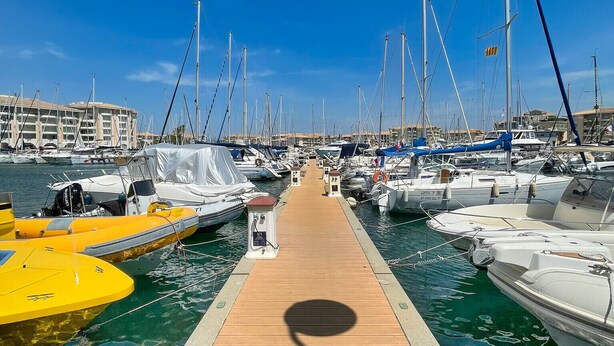 A marina with a wooden walkway leading to docked boats.