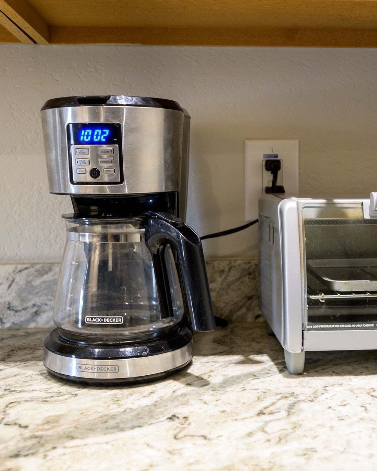 A coffee maker with a digital display on a kitchen counter.