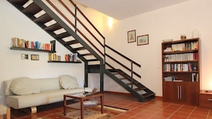 A living room with a sofa, coffee table, and bookshelves. - Casuzza di Gaia (Sicilia)