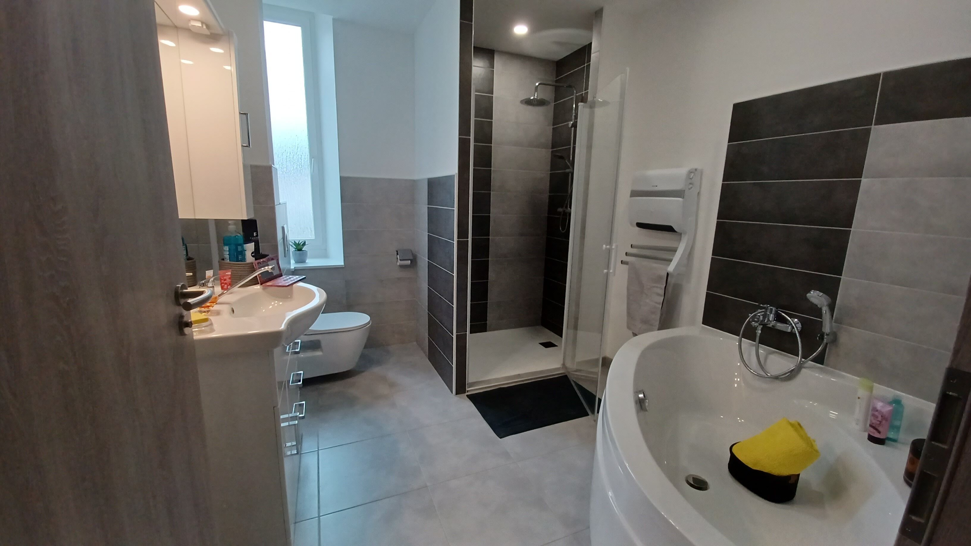 Un baño moderno con inodoro, lavamanos, ducha y bañera.