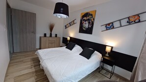 Ein Schlafzimmer mit Bett, Nachttischen, einem Kleiderschrank und Bildern an den Wänden.