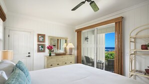 Een slaapkamer met een groot bed, een dressoir, een spiegel en uitzicht op de omgeving.