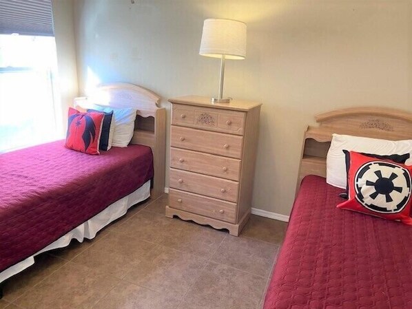 A bedroom with two beds, a dresser, and a lamp. - Goofy's Golf Retreat (Davenport)