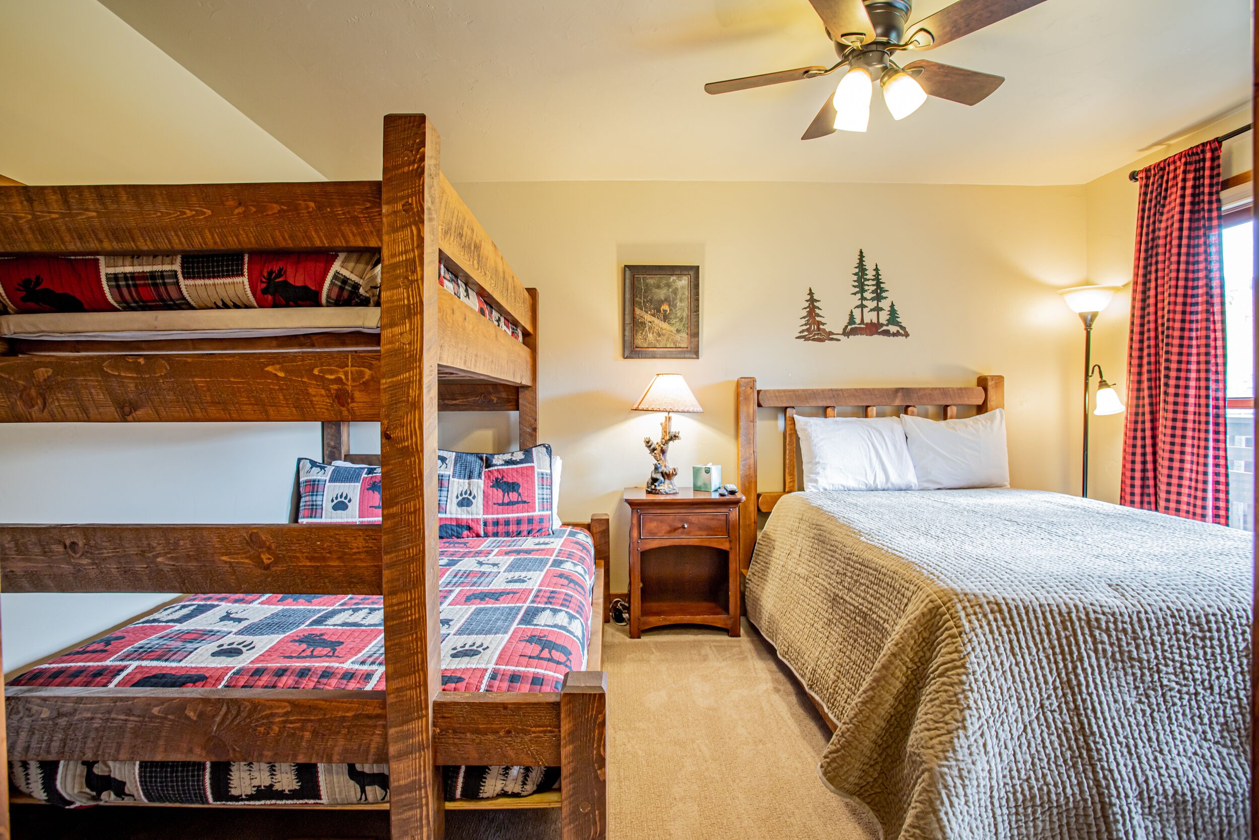 Quarto com beliche, criado-mudo com luminária e um quadro na parede.
