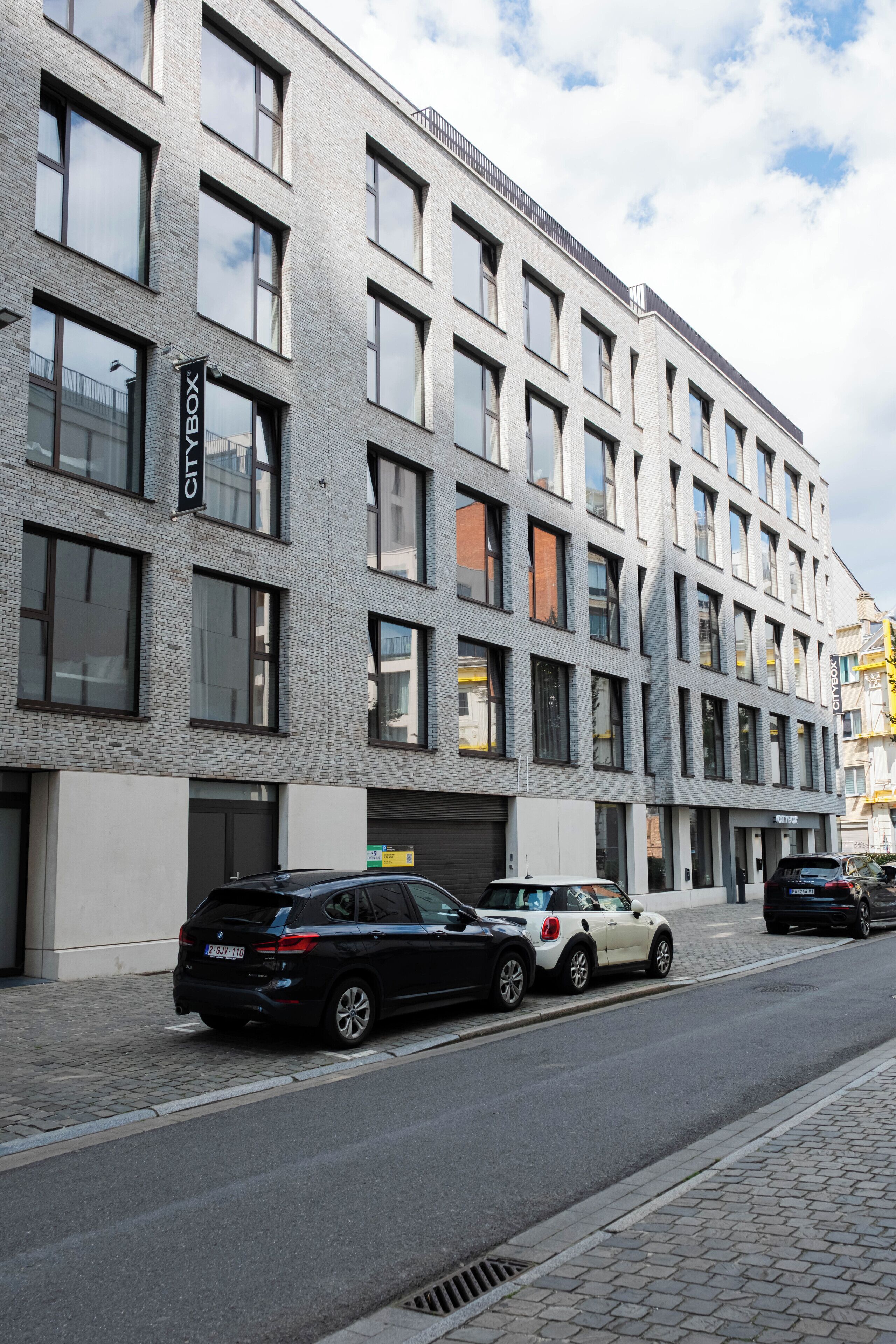 Un edificio moderno con fachada de ladrillo, múltiples ventanales y un letrero que dice 