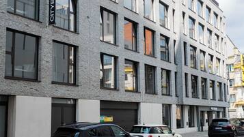 Un edificio moderno con fachada de ladrillo, múltiples ventanales y un letrero que dice