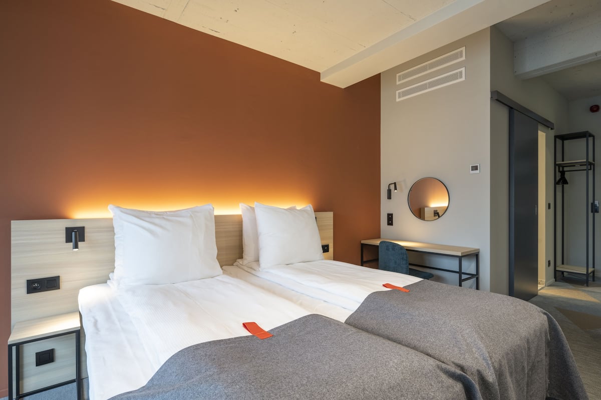 Een hotelkamer met een groot bed, nachtkastjes, een bureau en een douche.