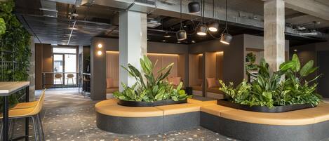 A modern interior with seating areas, plants, and a tiled floor.