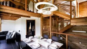 Un interior moderno con una zona de comedor, un sofá y una escalera.