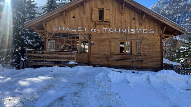 A wooden chalet with a sign reading "CHALET des TOURISTES" in front of a snowy mountain backdrop. - Tourist chalet (La Salle-les-Alpes)