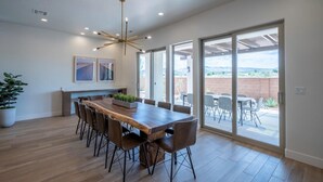 A spacious dining area with a wooden table and chairs, large windows, and a view of the outdoors. - Arcadia 55 | Pool Table * PRIVATE Hot Tub * BBQ (Santa Clara)