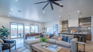 A spacious living room with a large sofa, a coffee table, and a dining area with chairs and a table. - Arcadia 55 | Pool Table * PRIVATE Hot Tub * BBQ (Santa Clara)
