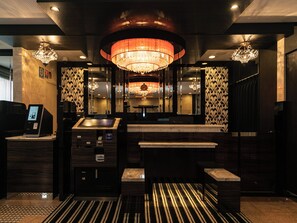 A modern hotel lobby with a reception desk, a self-service kiosk, and a large chandelier. - APA Hotel Nambakita Shinsaibashi Ekimae (Osaka)