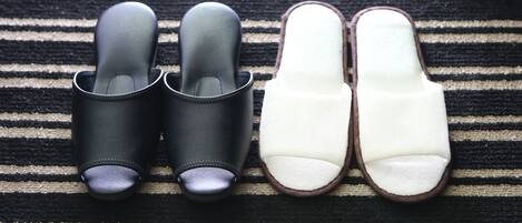A pair of black and white slippers on a striped fabric.