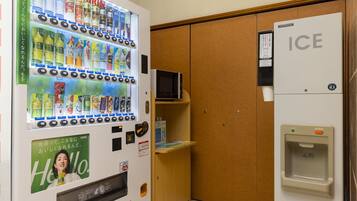 A vending machine with various beverages and a refrigerator with a water dispenser.