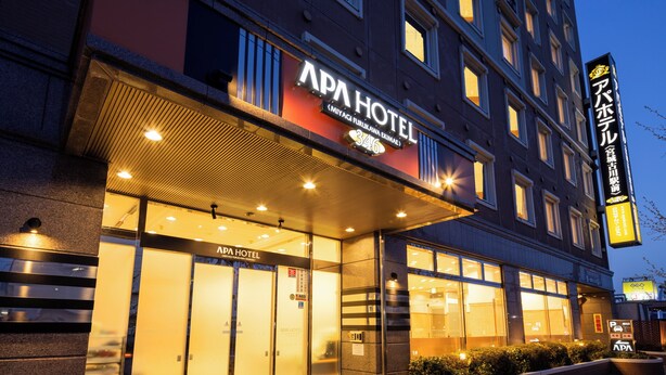 L’extérieur de l’hôtel APA se distingue par sa façade moderne, ses grandes fenêtres en verre et son entrée bien éclairée.
