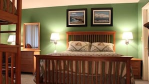 Une chambre à coucher avec un lit en bois, deux lampes de chevet et deux tableaux encadrés accrochés au mur.