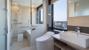A modern bathroom with a glass shower enclosure, a toilet, a sink, and a large mirror. - APA Hotel Keikyukamata Ekimae (Tokyo)