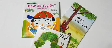 Three children's books with Japanese text, one featuring a character with a colorful hat.