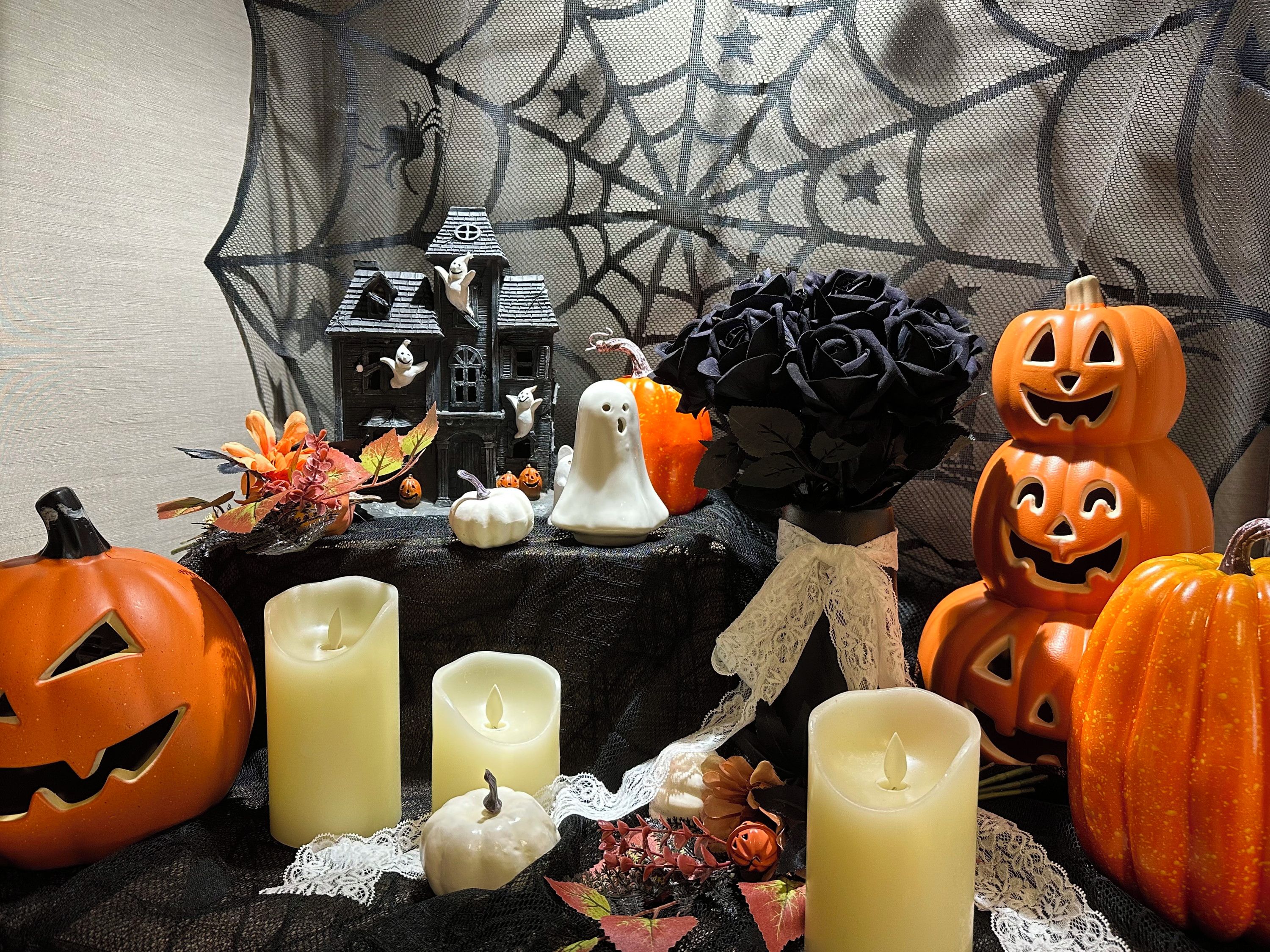 A Halloween-themed display with pumpkins, candles, and a decorative house.
