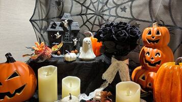 A Halloween-themed display with pumpkins, candles, and a decorative house.