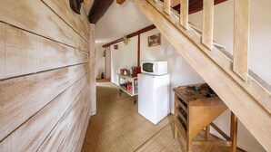 A narrow hallway with wooden walls and a wooden staircase. A white refrigerator and a microwave are visible in the background. - Family suite on 2 levels in a peaceful hamlet. Ideal for families (LE VERNET LA VARENNE)