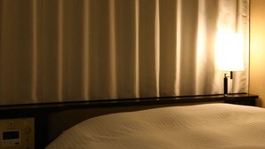 A hotel room with a bed, a nightstand with a control panel, and a lamp. - APA Hotel Ueno Ekimae (Tokyo)