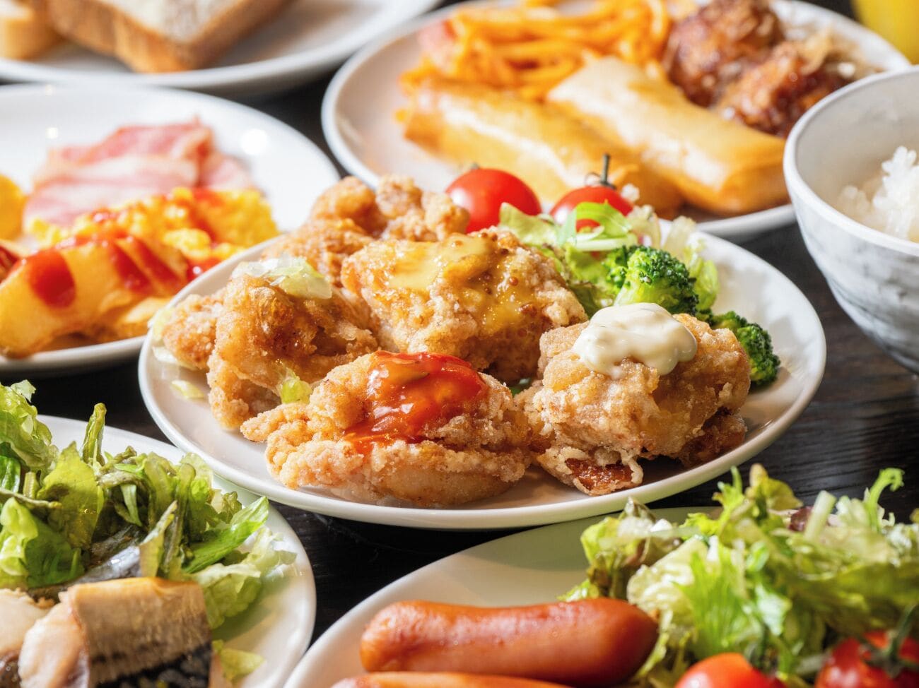 A variety of dishes including fried shrimp, salads, and other foods on a table.